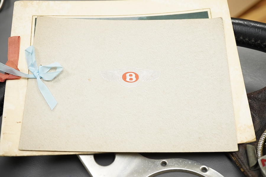 Racing ephemera, including; a Moto-lite steering wheel, a driver's leather cap, an enamelled Le Mans pilot’s radiator badge, signed photograph of Prince Michael Kent standing next to a 12 cylinder single seat racing car